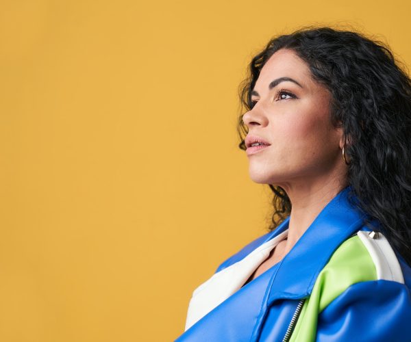 Photo of young girl in profile with interesting look isolated with yellow background
